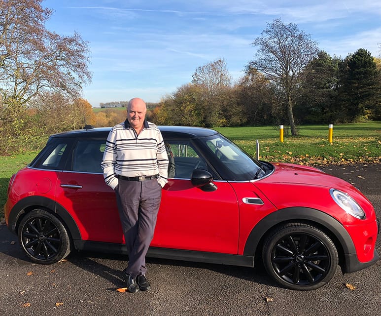 Dave Willis standing in front of a red mini